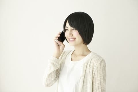 電話で問い合わせる女性